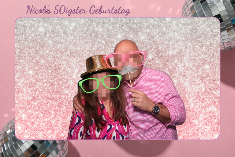 Zwei Gäste mit Spaßbrillen vor einem digitalen rosa Glitzerhintergrund zum 50. Geburtstag, Gesichter verpixelt
