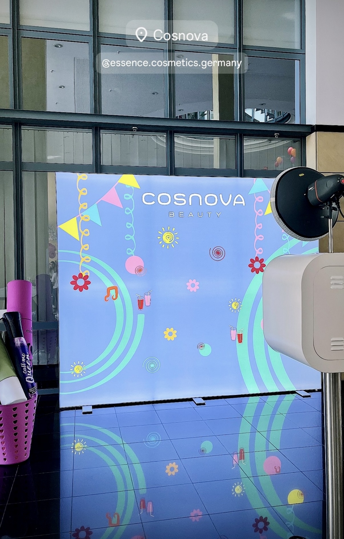 Fotobox Lite vor einer individuell gestalteten Cosnova-Rückwand mit bunten Blumen und Girlanden