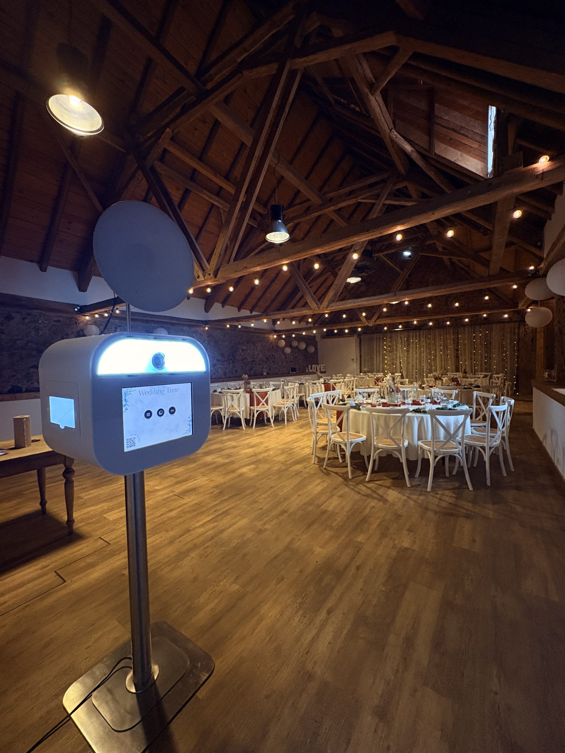 Vorderansicht der Fotobox Lite mit beleuchtetem Kamerabereich und Touchscreen im Hochzeitssaal der Obermühle Langenselbold