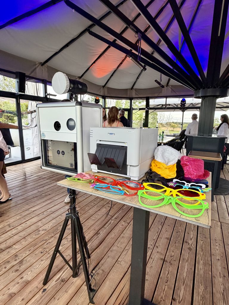 Fotobox Klassik mit externem Drucker, Studioblitz und bunten Accessoires bei einer Veranstaltung